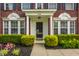 Inviting front entrance with decorative columns, manicured bushes, and colorful flowers at 10248 Noble Ct, Indianapolis, IN 46234