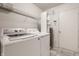 Well-equipped laundry room with modern washer, dryer, storage shelves, and tile flooring at 10248 Noble Ct, Indianapolis, IN 46234