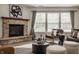 Bright and inviting living room featuring a stone fireplace, neutral tones, and ample natural light at 10248 Noble Ct, Indianapolis, IN 46234