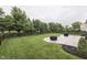 Expansive backyard with a lush green lawn, patio, and a charming wooden fence at 10510 Mcclain Dr, Brownsburg, IN 46112