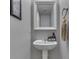 Cozy bathroom featuring a pedestal sink, decorative mirror, and charming accessories at 10510 Mcclain Dr, Brownsburg, IN 46112