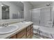 Bathroom with a double sink vanity, shower, and a bathtub with sliding glass doors at 10510 Mcclain Dr, Brownsburg, IN 46112