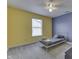 Cozy bedroom featuring blue and yellow walls, a ceiling fan, and a comfortable bed at 10510 Mcclain Dr, Brownsburg, IN 46112