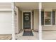 Charming front porch with decorative columns, a wreath on the door, and potted plants at 10510 Mcclain Dr, Brownsburg, IN 46112