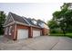 Spacious three-car garage featuring modern doors and exterior lighting on a brick home at 1188 Old Eagle Way, Greenwood, IN 46143