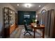 Sophisticated home office featuring a dark accent wall, plush rug, and ample shelving for organized storage at 1188 Old Eagle Way, Greenwood, IN 46143