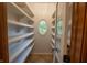 Walk-in pantry with built-in shelving and unique oval window for natural light at 1188 Old Eagle Way, Greenwood, IN 46143