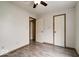 A clean bedroom with wood-look flooring, a ceiling fan, and white doors with brown trim at 12157 Longstraw Dr, Indianapolis, IN 46236