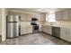 Modern kitchen with gray cabinetry, stainless steel appliances, and durable wood-look flooring at 12157 Longstraw Dr, Indianapolis, IN 46236
