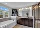 Bright bathroom featuring a soaking tub, stylish vanity, and a large window at 1313 Brentford Ln, Greenwood, IN 46143