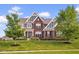 Beautiful two-story brick home with landscaped front yard and mature trees at 1313 Brentford Ln, Greenwood, IN 46143