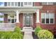Charming brick home entrance with decorative glass door, white columns, and manicured landscaping at 1313 Brentford Ln, Greenwood, IN 46143