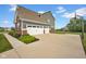 View of the exterior of a home's three car garage with a wide driveway and basketball hoop at 1313 Brentford Ln, Greenwood, IN 46143