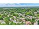 Aerial view capturing the expanse of homes set among lush greenery with a distant cityscape on the horizon at 140 W Hampton Dr, Indianapolis, IN 46208