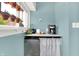 Compact bar area includes mini-fridge, counter space, and plants hanging by the window at 140 W Hampton Dr, Indianapolis, IN 46208