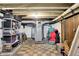 Unfinished basement with checkerboard tile, water heater, storage shelving, and open ceiling at 140 W Hampton Dr, Indianapolis, IN 46208