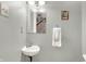 Half bathroom with wall sink, decorative mirror, and gray painted walls at 140 W Hampton Dr, Indianapolis, IN 46208