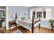 Bright bedroom featuring hardwood floors, blue walls, a wooden four-poster bed, and many windows at 140 W Hampton Dr, Indianapolis, IN 46208