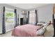 Cozy bedroom with large windows, chevron curtains, a black dresser, and a comfortable bed at 140 W Hampton Dr, Indianapolis, IN 46208