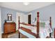 Bedroom featuring hardwood floors, soft blue walls, a wooden four-poster bed, and a traditional dresser at 140 W Hampton Dr, Indianapolis, IN 46208