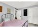 Bedroom with white walls, black metal bed frame, and 2 white doors, one leading to another room at 140 W Hampton Dr, Indianapolis, IN 46208
