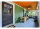 Charming front porch with a cozy seating area, complemented by a ceiling fan and an inviting entrance way at 140 W Hampton Dr, Indianapolis, IN 46208