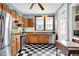 Kitchen with checkerboard floors, stainless steel appliances, and vintage-style oak cabinetry at 140 W Hampton Dr, Indianapolis, IN 46208