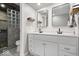 Modern bathroom featuring double sinks, mirrors, and walk-in shower with a glass block wall at 1408 126Th St, Carmel, IN 46033