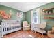 Bright Bedroom with hardwood floors, crib, rocking chair, shelves, and a view to the outside at 1408 126Th St, Carmel, IN 46033