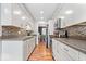 Updated kitchen with white cabinetry, stainless steel appliances, stone countertops and a mosaic backsplash at 1408 126Th St, Carmel, IN 46033