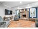 Cozy living room features a brick fireplace, comfortable seating, and hardwood floors at 1408 126Th St, Carmel, IN 46033
