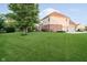 Expansive backyard with lush green lawn and mature tree, offering ample space for outdoor activities at 14662 Woodstone Cir, Fishers, IN 46037