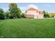 Expansive backyard featuring lush green lawn, mature trees, and a view of the home's exterior at 14662 Woodstone Cir, Fishers, IN 46037