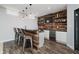 Finished basement bar with wood accents, modern lighting, wine fridge, seating, and a sleek countertop at 14662 Woodstone Cir, Fishers, IN 46037