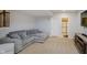 Comfortable basement lounge area with a plush gray sectional, TV, and doorway to an en-suite bathroom at 14662 Woodstone Cir, Fishers, IN 46037