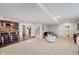 Open basement layout with a bar area, carpeted lounge, and access to the bathroom and staircase at 14662 Woodstone Cir, Fishers, IN 46037
