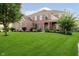 Beautiful brick home featuring a lush green lawn, mature trees, and charming architectural details at 14662 Woodstone Cir, Fishers, IN 46037