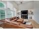Open living space with tall windows, cozy leather sectional, and stylish fireplace at 14662 Woodstone Cir, Fishers, IN 46037