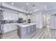 Open concept kitchen features an island with quartz countertop, modern appliances, and wood grain floors at 14844 Higgins Dr, Westfield, IN 46074