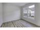 Bright, empty room showcases a large window, neutral paint, white trim, and wood grain floors at 14844 Higgins Dr, Westfield, IN 46074