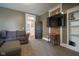Comfortable living room with gray sofa, brick accent wall, shelving and adjacent dining space at 1512 Bellefontaine St, Indianapolis, IN 46202