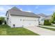 Spacious two-car garage with a white door, set in a well-maintained lawn with manicured landscaping at 1655 Avondale Dr, Westfield, IN 46074