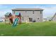 Expansive green backyard with a playset and sliding glass doors to the home at 1715 Foudray S Cir, Avon, IN 46123