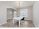 Light-filled dining area with a contemporary table, wood-look floors, neutral paint, and a bright window at 1715 Foudray S Cir, Avon, IN 46123