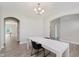 Clean dining room with a simple table and chandelier, neutral walls, and arched doorways leading to other rooms at 1715 Foudray S Cir, Avon, IN 46123