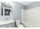 Clean bathroom featuring a modern vanity, sleek mirror, and a bathtub with a shower and white surround at 1723 Fletcher Ave, Indianapolis, IN 46203