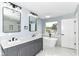Bright bathroom featuring double vanity sinks, standing tub near a window, and a walk-in shower at 1723 Fletcher Ave, Indianapolis, IN 46203