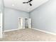 Spacious bedroom with a ceiling fan, two closets, carpet, and access to another room at 1723 Fletcher Ave, Indianapolis, IN 46203