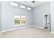 This unfurnished bedroom has neutral walls and carpet, multiple windows, and tall ceilings at 1723 Fletcher Ave, Indianapolis, IN 46203