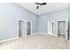 Spacious bedroom features a ceiling fan, natural lighting, carpet, and a hallway leading to a bathroom at 1723 Fletcher Ave, Indianapolis, IN 46203